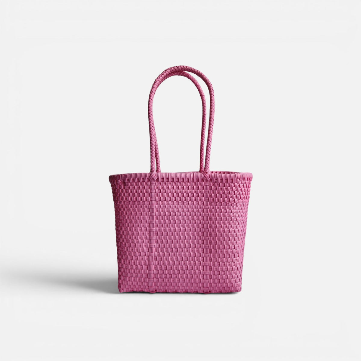 Alma Tote Chica in Pink — handgeflochtene Tragetasche aus recyceltem Kunststoff, kompakte Grösse mit langen Henkeln