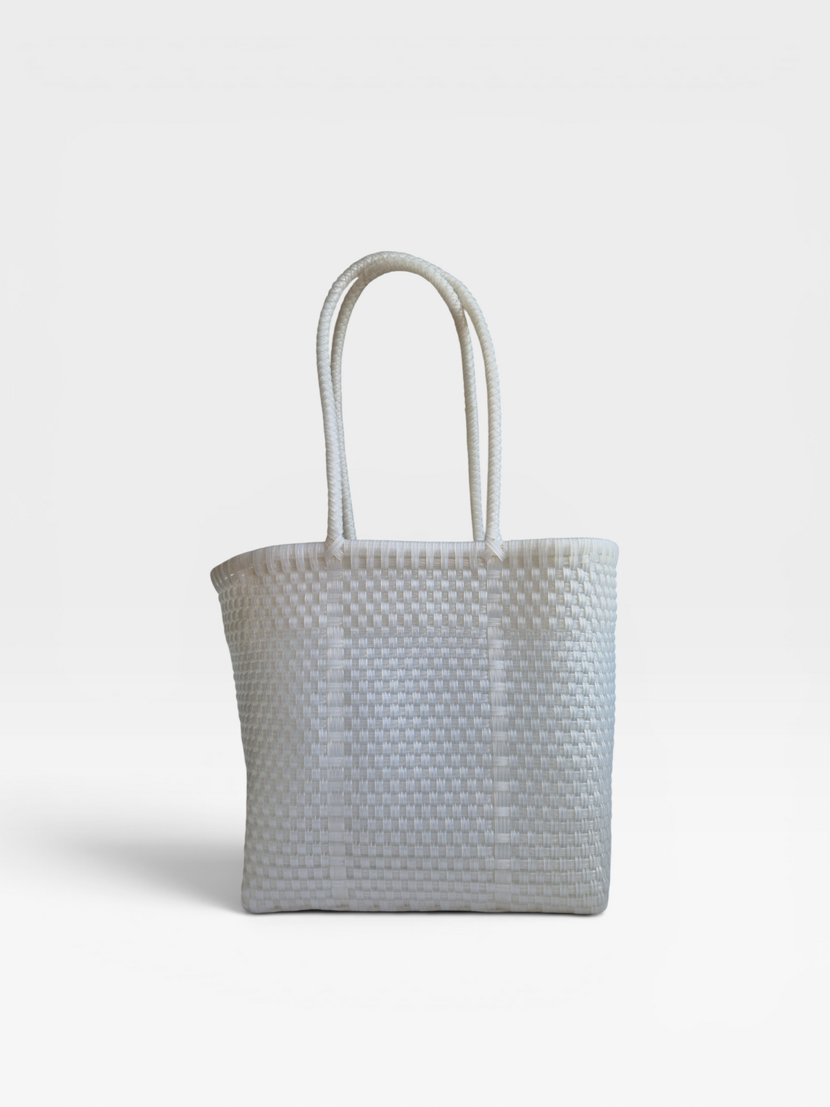 Alma Tote Chica in Clear — handgeflochtene Tragetasche aus recyceltem Kunststoff, kompakte Grösse mit langen Henkeln